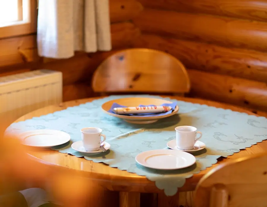 Runder Holztisch mit Tischdecke und 2 Kaffeegedecken