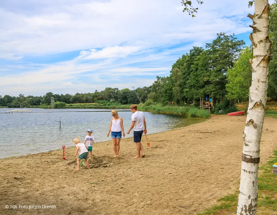 Familie am Strand des Alfsees mit Kindern, die im Sand spielen